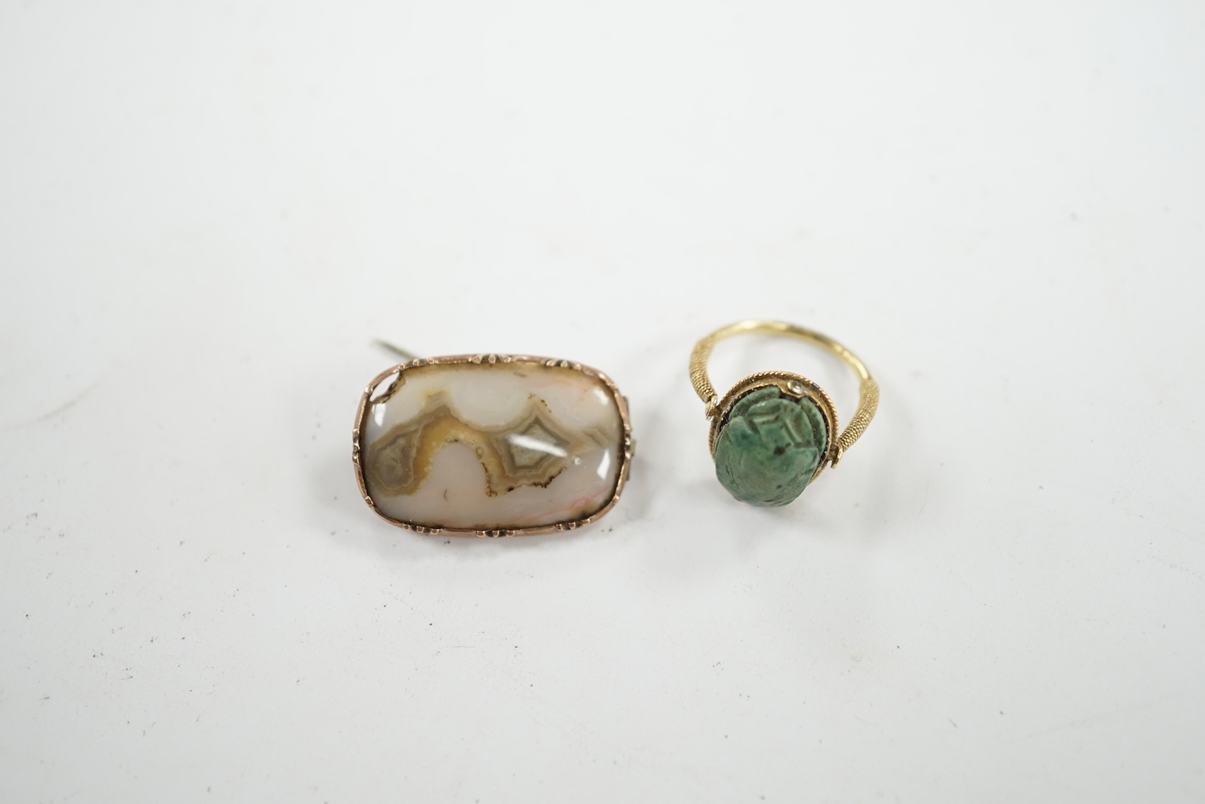 An antique yellow metal 'Scarab' ring and a banded agate set brooch. Condition - poor to fair